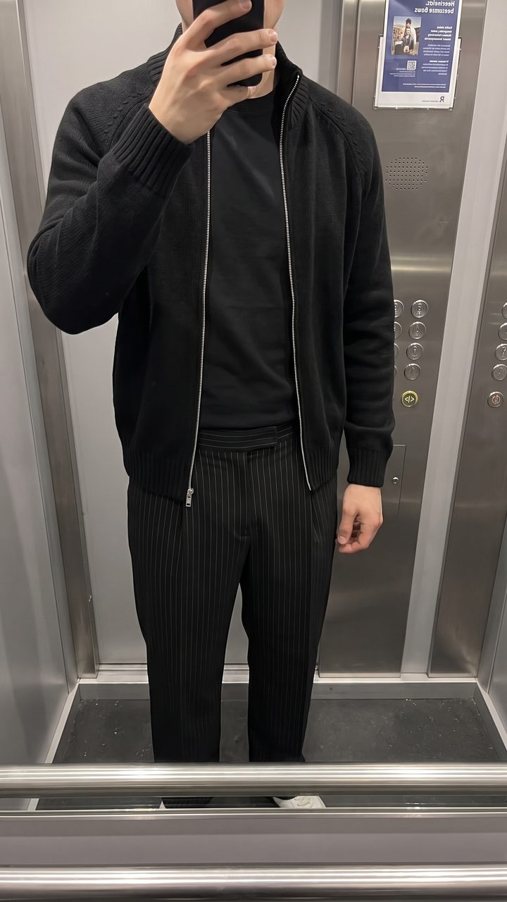 Black zip knit over pinstripe pleats
